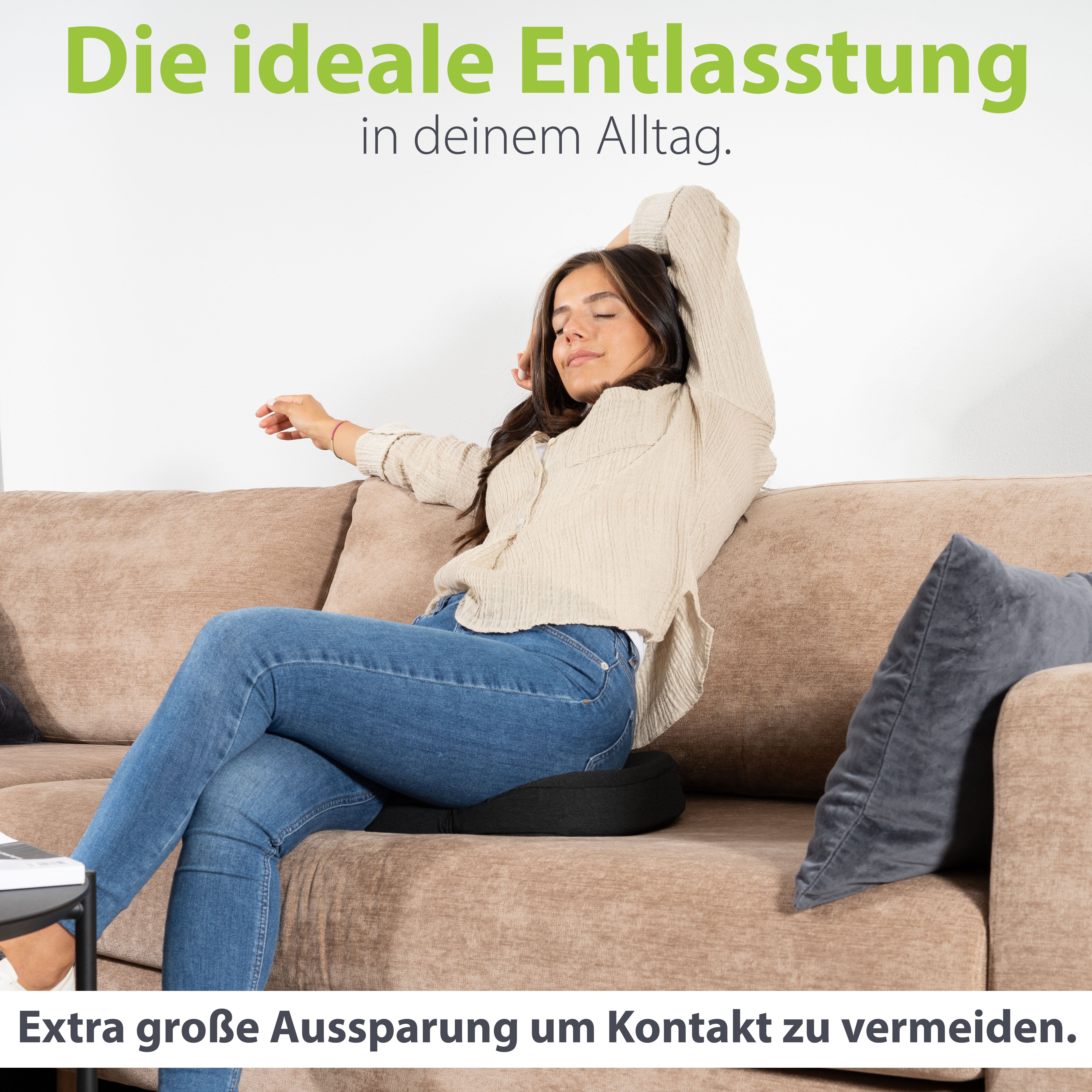 Frau entspannt auf dem Sofa mit erhobenen Armen, sitzend auf einem ergonomischen Kissen von feela, das durch seine extra große Aussparung Druckkontakt vermeidet.