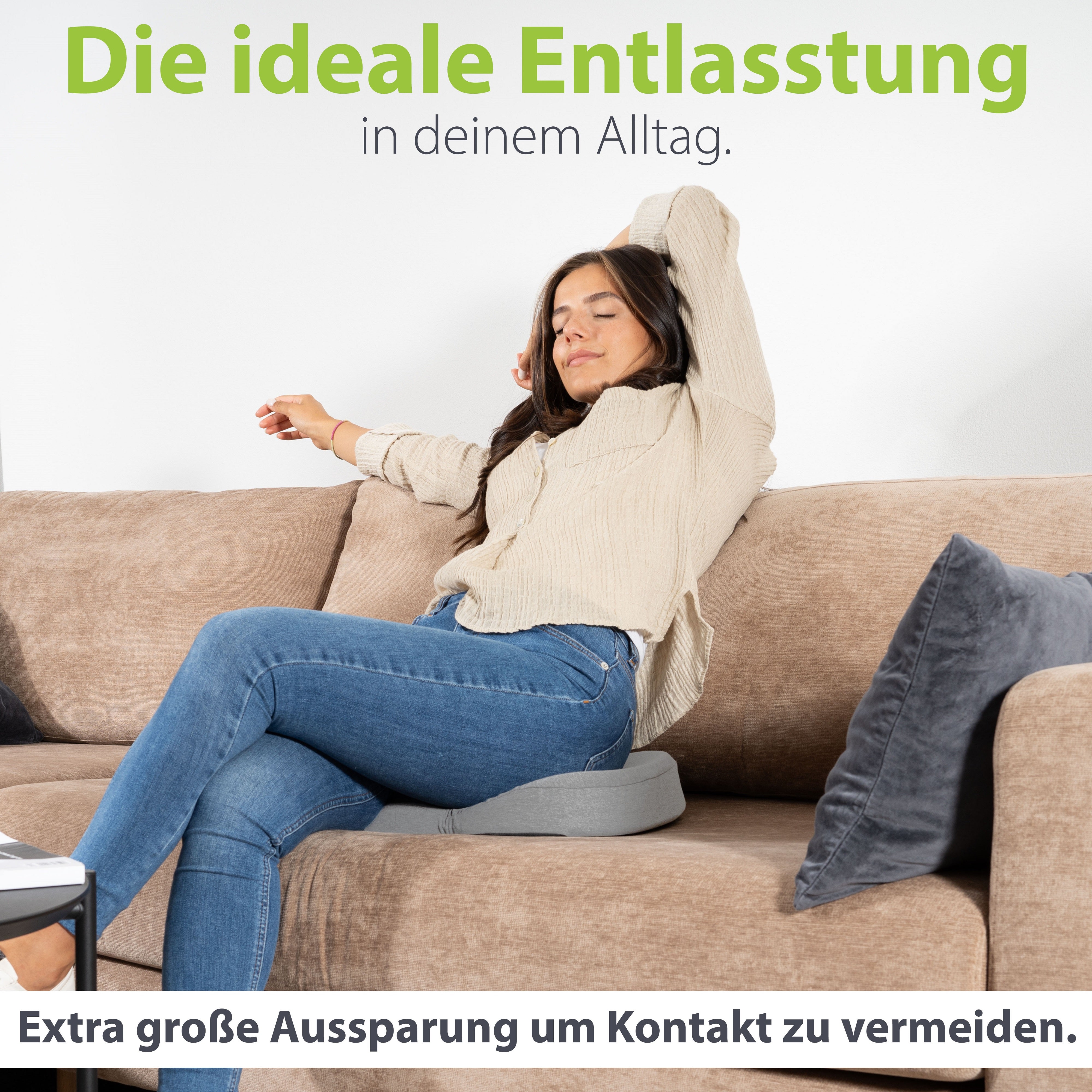 Frau entspannt auf dem Sofa mit erhobenen Armen, sitzend auf einem ergonomischen Kissen von feela, das durch seine extra große Aussparung Druckkontakt vermeidet.